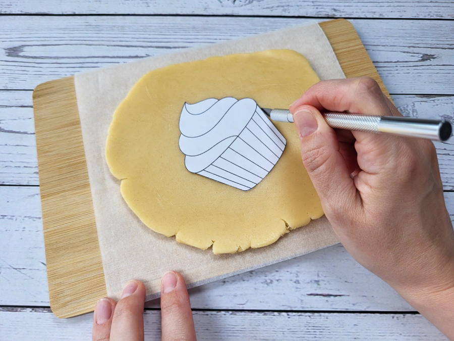 Cutting cookie dough with a knife using a paper template