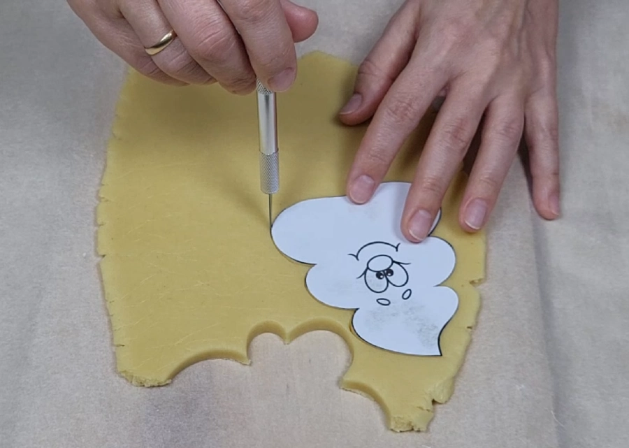 Cutting cookie dough using a paper template and knife