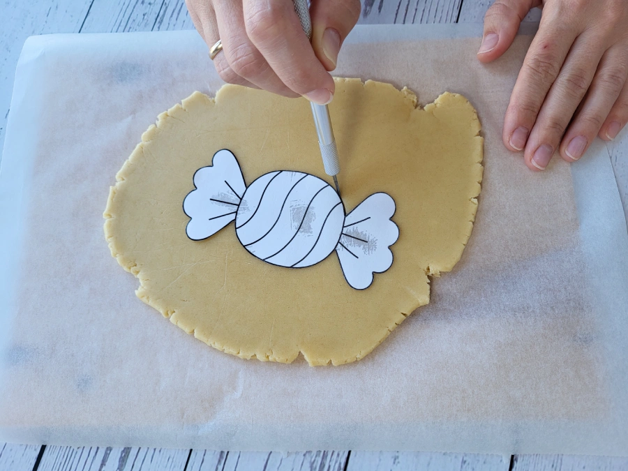 Cutting cookie dough with a paper template and knife