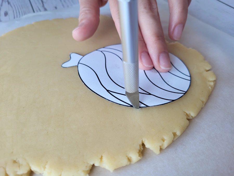Holding a knife perpendicular while cutting cookie dough